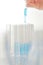 Hand of chemist use pipette drops blue chemical liquid in test tube in laboratory