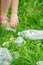 Hand of child cleans green grass from plastic trash