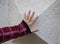 hand of a child on the wall made with stones in the shape of a t