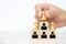 Hand choose chess on wooden toy blocks stacked in a pyramid with people icon