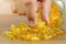Hand choose a cod liver oil  capsule from a pile of cod liver oil or fish oil