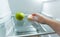 Hand choosing donut instead of apple lying in fridge