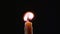 Hand with a cigarette lighter ignites one candle. Black background. Close up