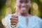 Hand, closeup and thumbs up by black woman showing yes, recommendation or thank you on bokeh background. Zoom, hands and