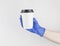 Hand with coffee paper cup, coronavirus protection. Mockup of female hand holding a coffee paper cup. Copy space. Coffee cup in