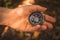 Hand with the compass in forest, outdoor navigation concept background photo