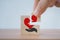 Hand completed red heart shaped over hand icon on wooden block cubes, square shape, for health insurance, organ donation concept