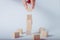 Hand completing tower made of wooden cubes