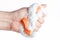 Hand compresses a soapy sponge for washing dishes on a white background
