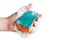 Hand compresses a soapy sponge for washing dishes on a white background