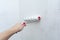 Hand with a construction roller in the process of priming the wall. The concept of renovation and decoration of the room.