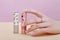 Hand cosmetics nails coloring and care, professional manicure and care product. Hand lying on a colored paper background