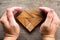 Hand cover tangram puzzle in heart shape on wood background