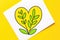 Hand-crafted heart with vivid green leaves, set against a lively yellow backdrop, depicting environmental love