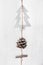 Hand Crafted Wood Christmas Tree Ornament Hanging on Twine with Pine Cone White Wood Barn Board Background. Scandinavian Style.