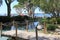 Hand crafted wood walkway over peaceful water, with trees and people walking along the beach in the distance