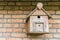 Hand crafted wooden bird house shelter for birds hanging on a brick wall