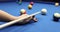 Hand with cue pointing at billiard ball at table