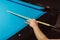 Hand with cue stick on blue billiard table