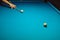 Hand with cue stick pointing on a ball on blue billiard table