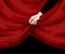 Hand with curtain edge. Woman holding red frame. Arm opening velvet drapery. Theater stage drape. Scarlet cloth with