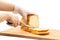 Hand cutting homemade Japanese Hokkaido bread on wooden board isolated.