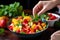 hand delicately adding mint leaves to a fruit salad