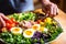 a hand delicately placing a vegetable on nicoise salad