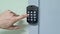 The hand dials the code on the combination door lock.
