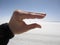 Hand with Distant People in Desert