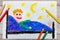 Hand drawing and crayons: smiling little boy lying in a bed.