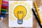 Hand drawing Light Bulb with wax crayons. Wooden background