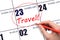 Hand drawing a red circle and writing the text TRAVEL on the calendar date 23 February. Travel planning.