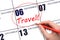 Hand drawing a red circle and writing the text TRAVEL on the calendar date 6 December. Travel planning.