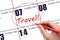 Hand drawing a red circle and writing the text TRAVEL on the calendar date 7 February. Travel planning.