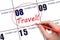 Hand drawing a red circle and writing the text TRAVEL on the calendar date 8 February. Travel planning.