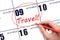 Hand drawing a red circle and writing the text TRAVEL on the calendar date 9 October. Travel planning.
