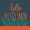 Hand drawn blue wild grass. Orange text Hello Autumn on gray blue background. The leaves are braided with letters