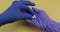 Hand dressed in blue medical glove puts two white oval pill into other hand