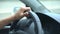 Hand of the driver on the car steering wheel while driving on the highway