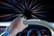 Hand of driver holding steering wheel with abstract speed motion light lines background