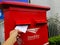 hand dropping envelope into postbox