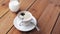 Hand dropping sugar into coffee cup on table