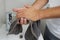 Hand drying with towel in a bathroom with white background