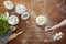 Hand dusting dough with flour wooden kitchen surface