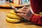 Hand of elderly man uses electronic device resting against bananas