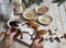 The hand of an elderly woman decorates Christmas cookies in the shape of a deer baked at home for the holiday