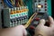 Hand of an electrician tests electrical installations and wires on relay protection system, Generative AI