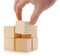The hand establishes a wooden cube