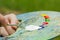 The hand of a European artist holds a mastekhin smeared in oil paint and a palette against the background of a green lawn. Blurred